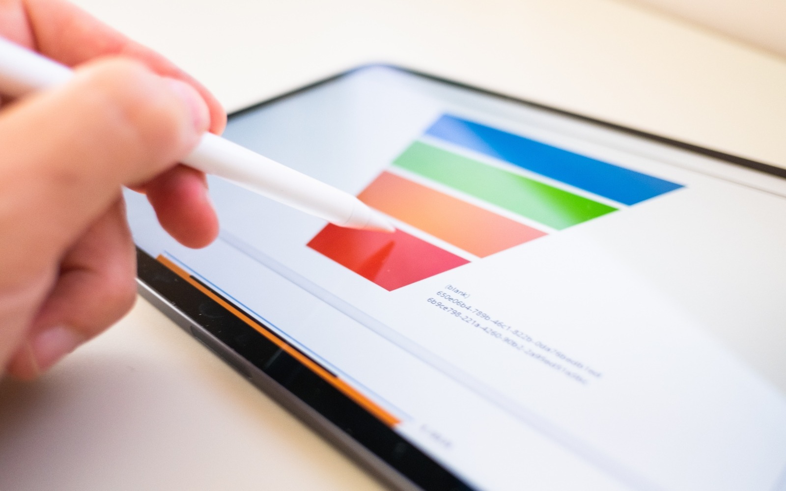 Person using a stylus on a tablet reviewing data charts used in B2B content funnel planning and organic search strategy